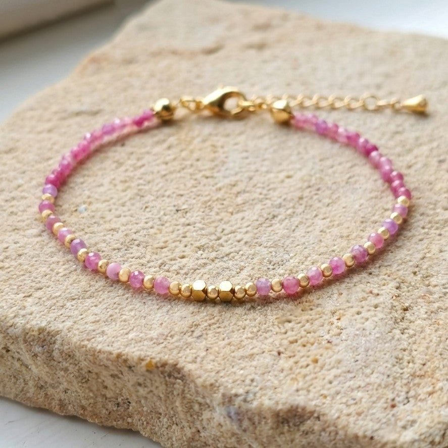 Boho beaded bracelet with natural pink strawberry quartz gemstone beads with natural inclusions and speckles, on a light stone background