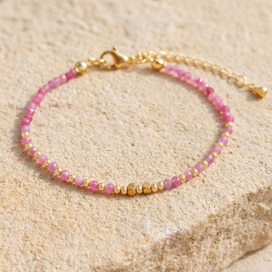 Boho beaded bracelet with natural pink strawberry quartz gemstone beads with natural inclusions and speckles, on a light stone background