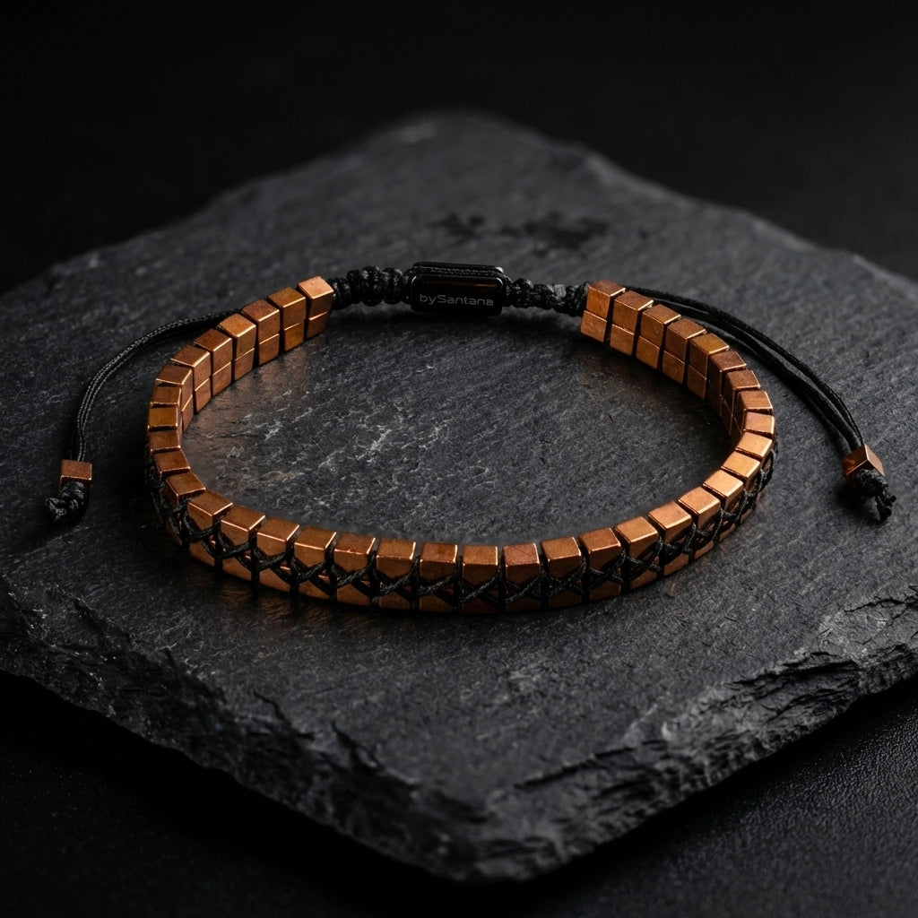Men's hematite bracelet with copper cube beads woven together and an adjustable cord, on a dark background