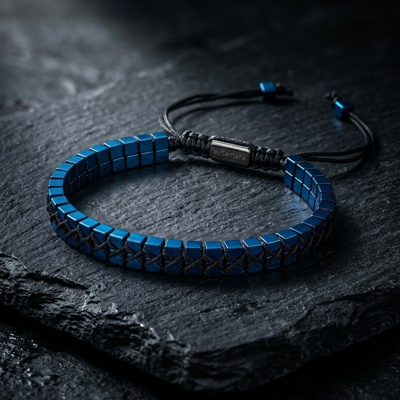 A men's metallic blue Hematite beaded bracelet with cube beads and adjustable cord on a dark surface