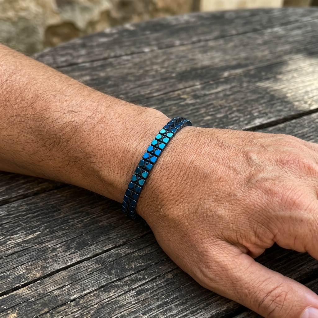Hand wearing a blue beaded bracelet on a wooden surface
