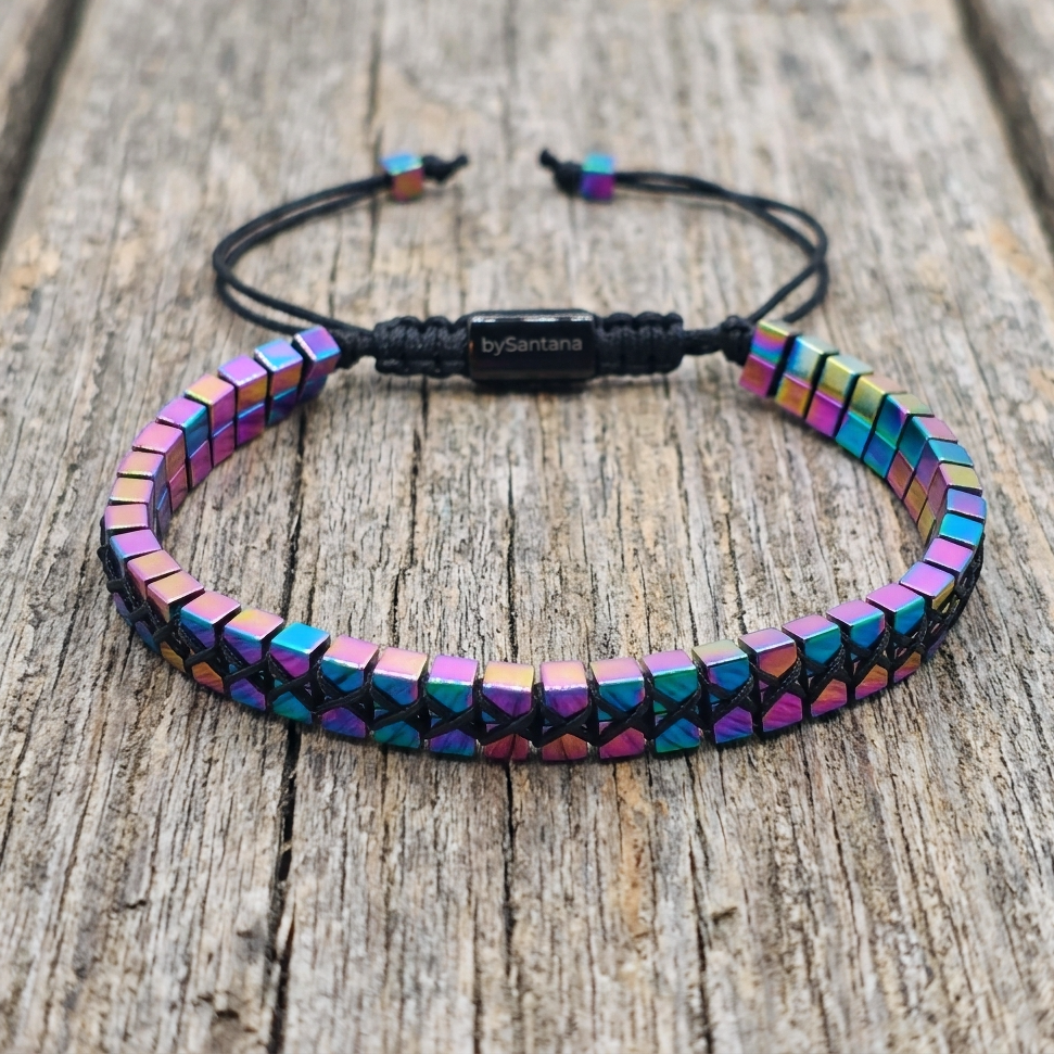A men's metallic multicolour rainbow Hematite beaded bracelet with cube beads and adjustable cord on a wooden surface