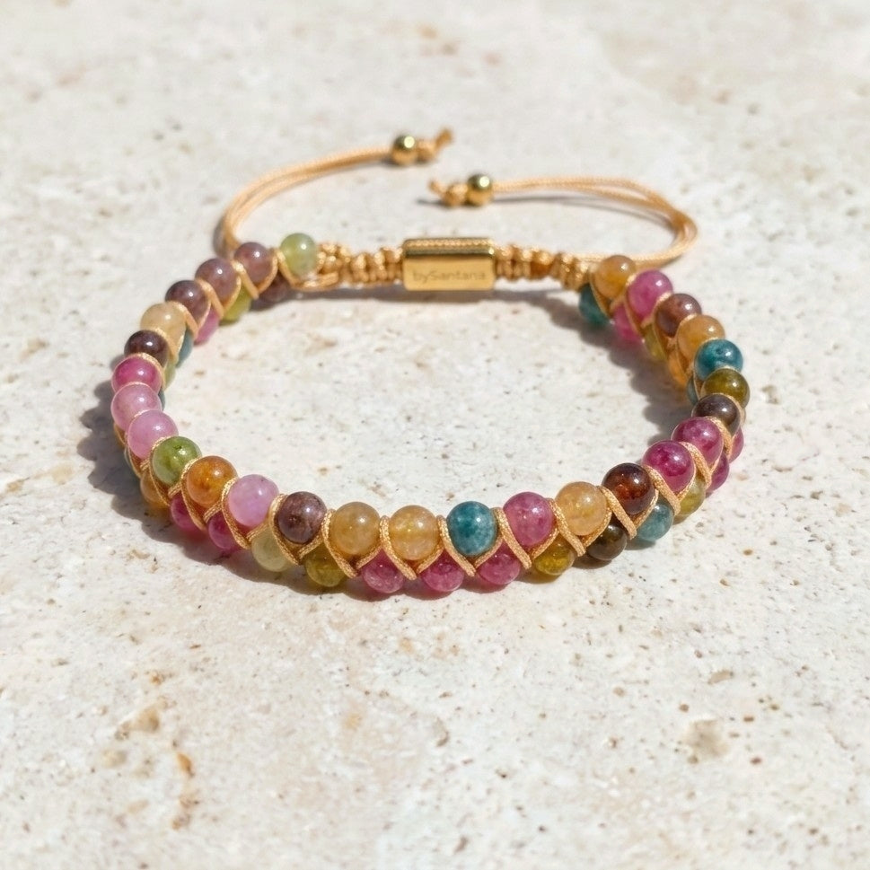 Multicolored Tourmaline beaded gemstone bracelet with beige cord wrapping on a light background