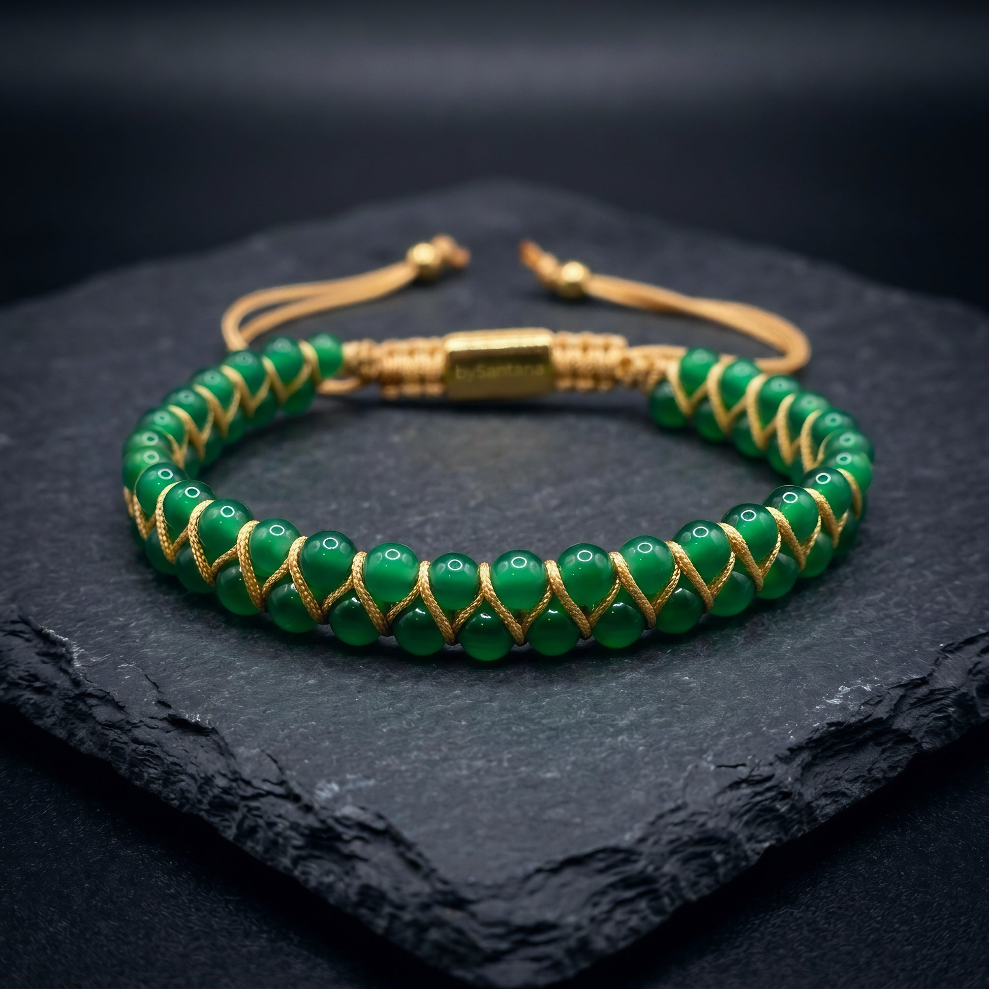 Green agate gemstone beaded bracelet, woven with a double row of natural stone beads, on a dark stone surface
