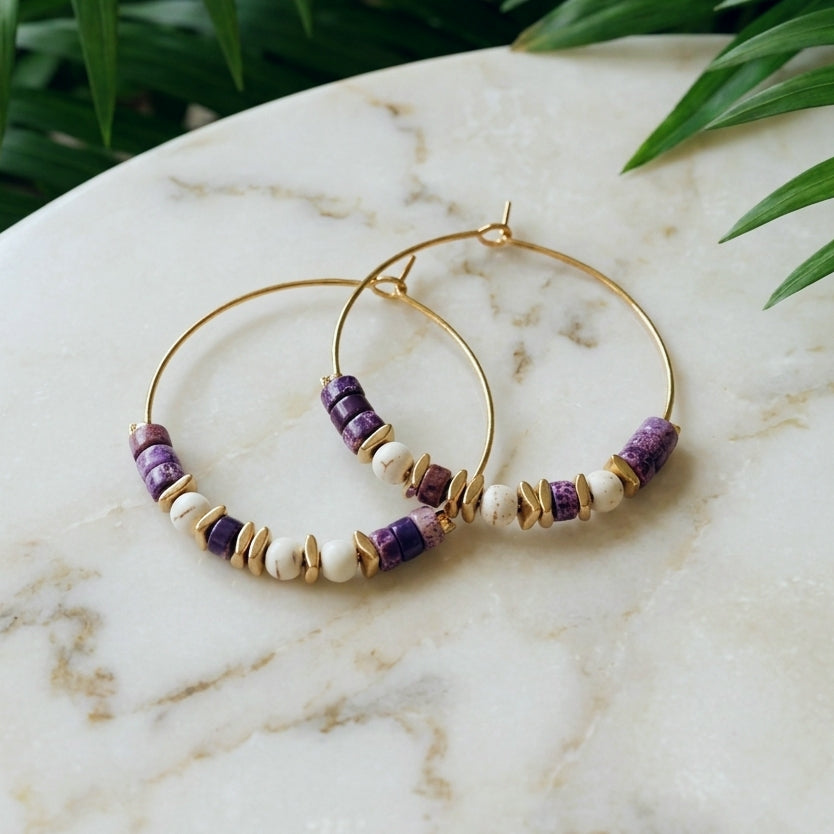 Boho style gold copper wire hoop earrings with purple sea sediment jasper and stainless steel beads, on a marble surface