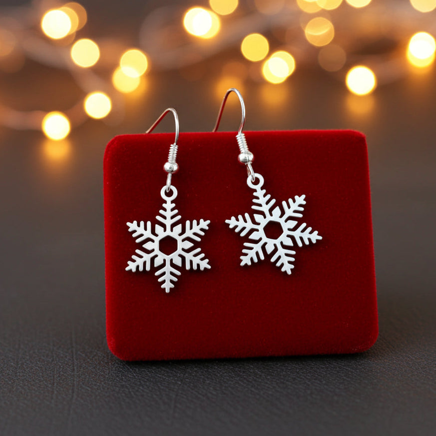 Snowflake earrings on a red velvet stand with Christmas lights in the background