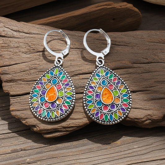 Colorful teardrop earrings on a wooden surface
