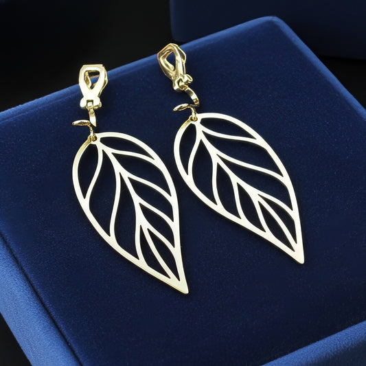 Large gold stainless steel leaf earrings with clip-ons on a blue background