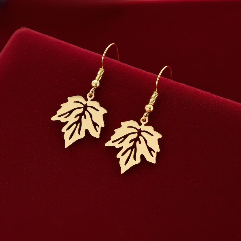 Gold stainless steel leaf earrings with hooks on a red background