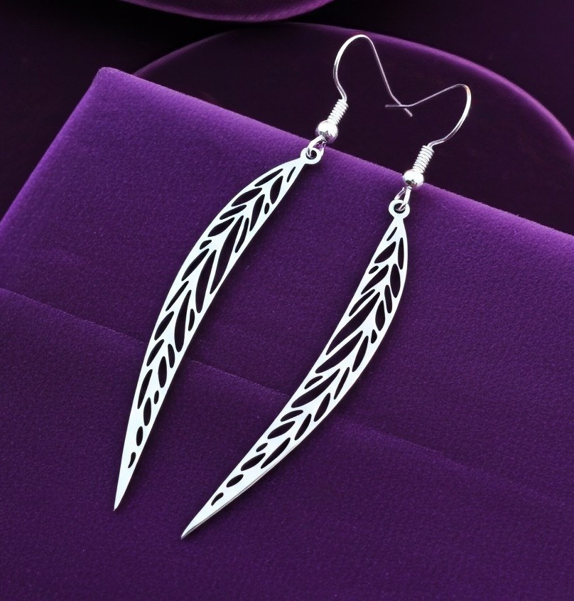 Long pointy stainless steel leaf earrings with silver hooks on a purple background
