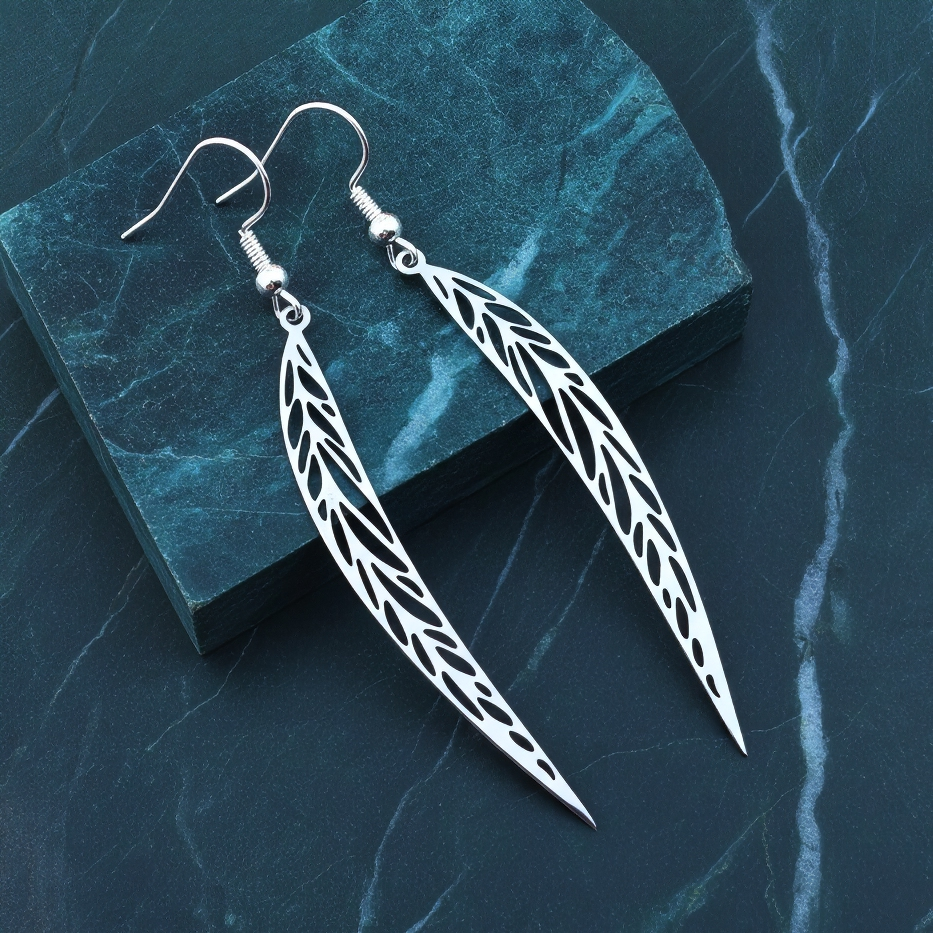 Long pointy stainless steel leaf earrings with silver hooks on a blue marble background