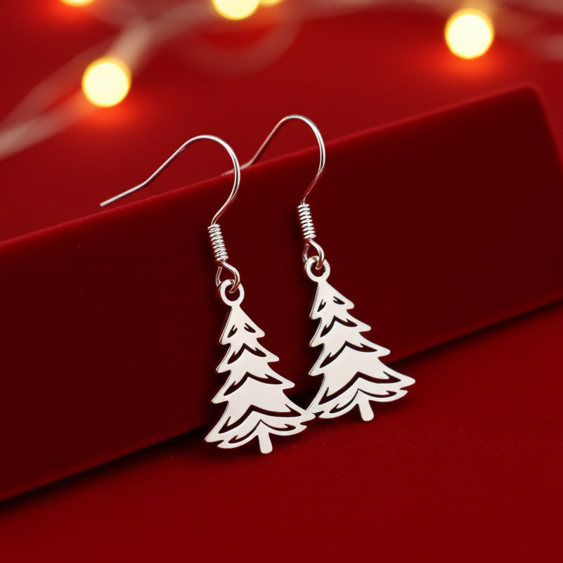 Silver Christmas tree earrings on a red stand with a festive background