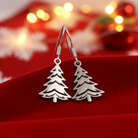 Silver Christmas tree earrings on a red stand with a festive background