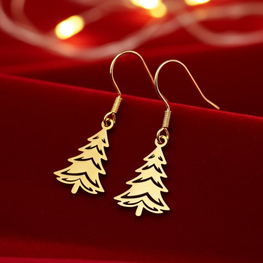 Festive Christmas tree earrings made out of gold stainless steel and hook earrings, on red velvet with lights in the background.