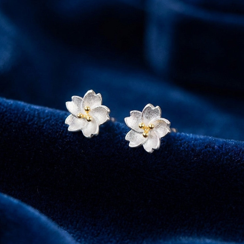 925 Silver flower stud earrings with gold pollen on a blue velvet surface