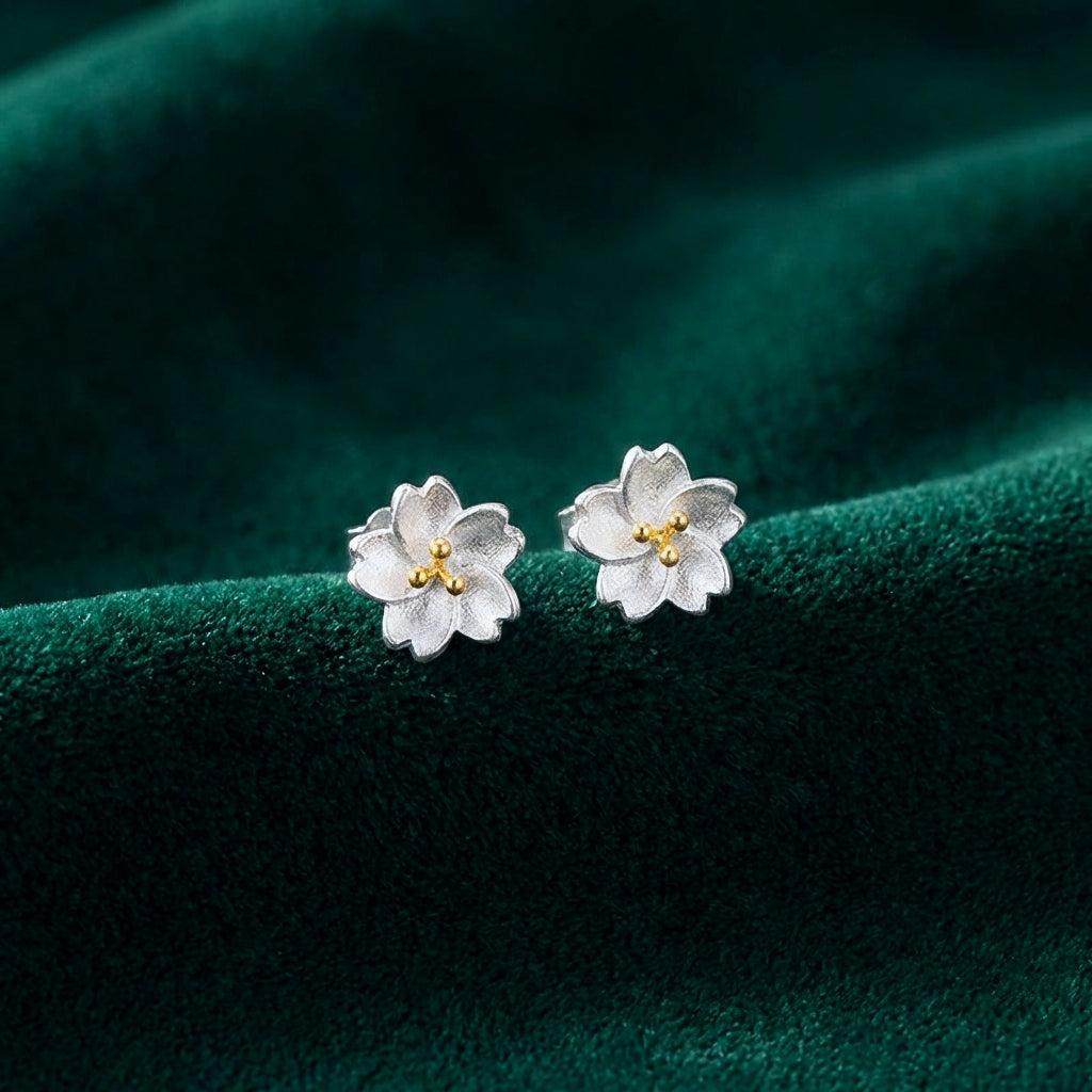 Sterling silver flower stud earrings on a green background