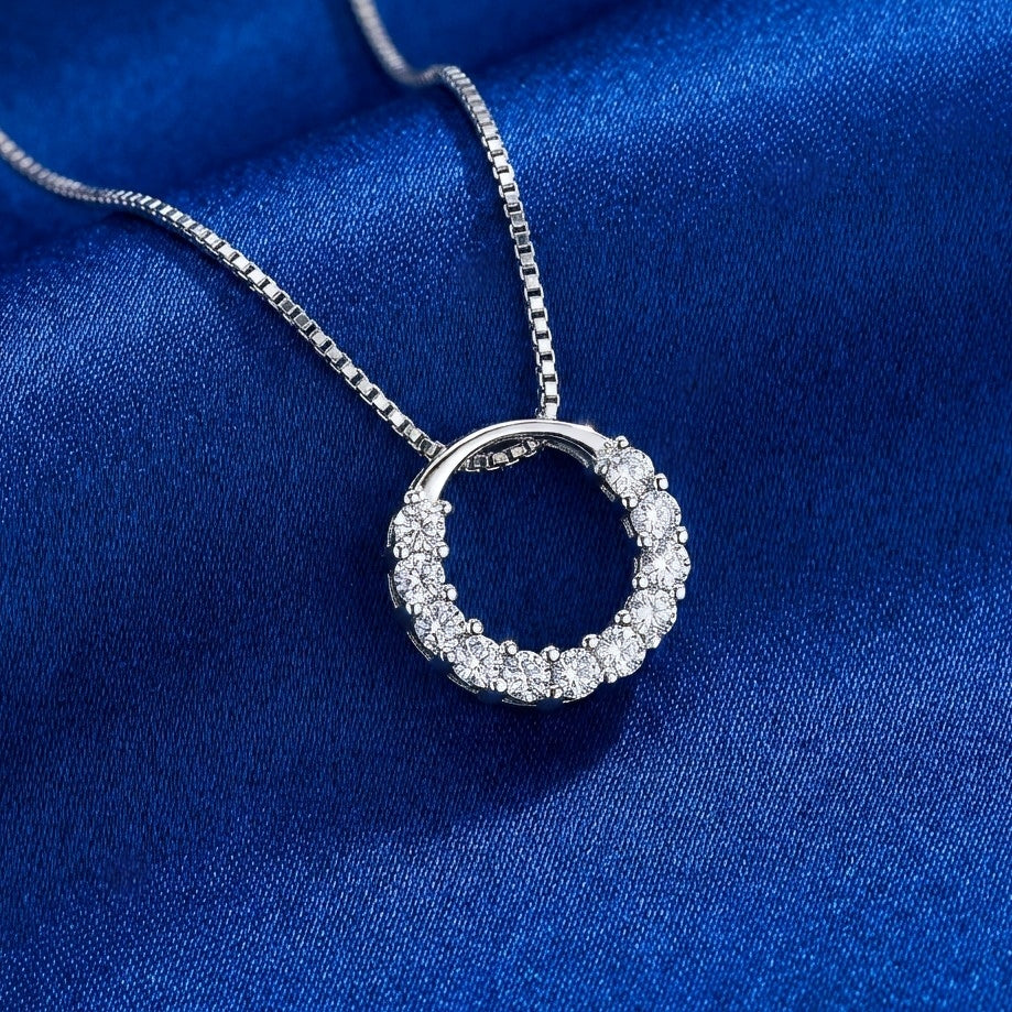 Sparkly round circle 925 silver pendant with crystals with a box chain necklace on a blue background