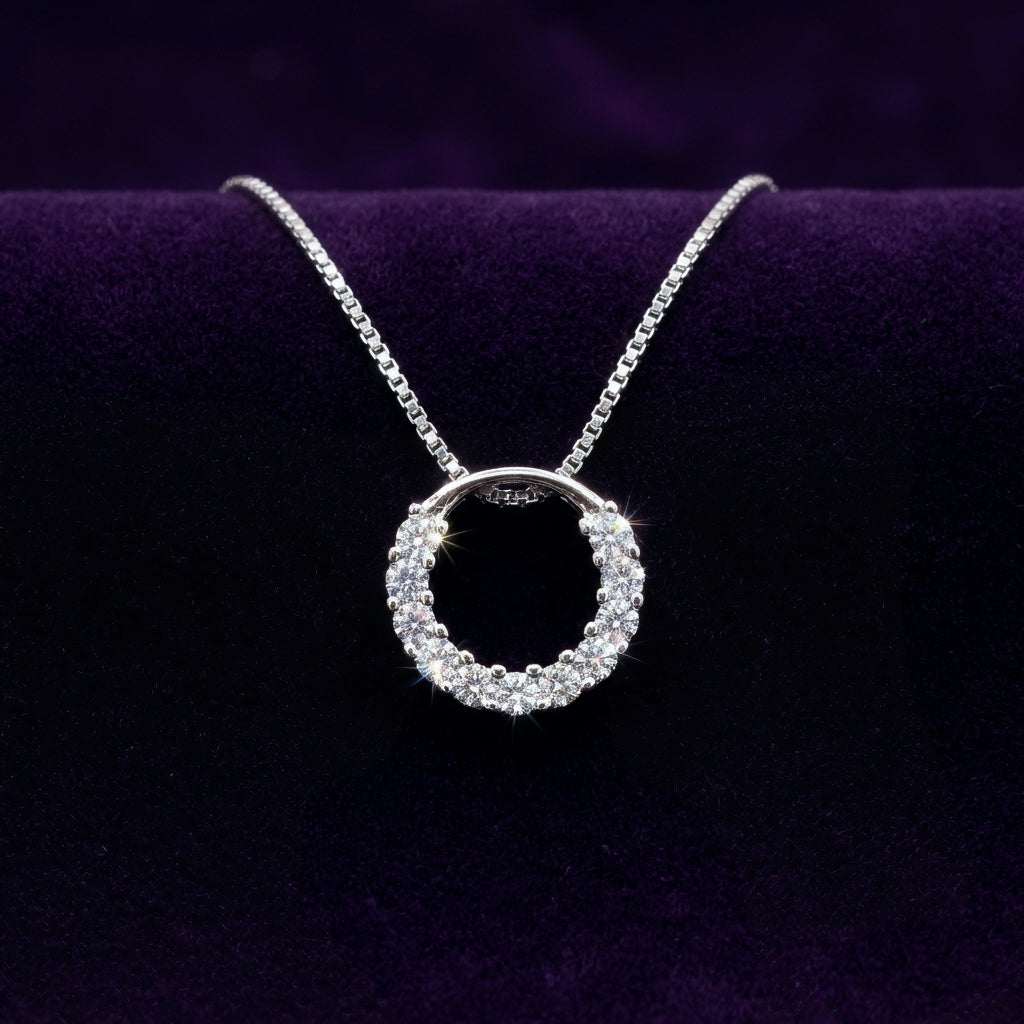 Sparkly round circle 925 silver pendant with rhodium plating and crystals catching the light, with a box chain necklace on a purple background