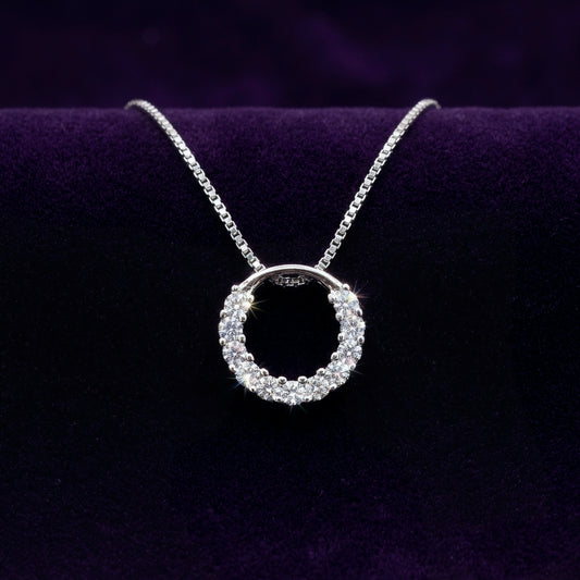 Sparkly round circle 925 silver pendant with rhodium plating and crystals catching the light, with a box chain necklace on a purple background