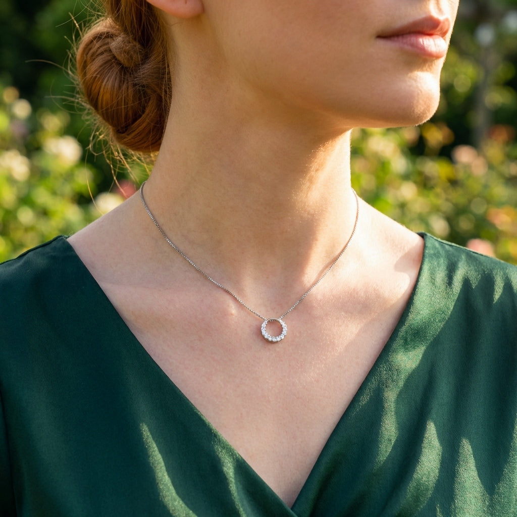 A woman wearing a sparkly round circle 925 silver pendant with crystals with a box chain necklace