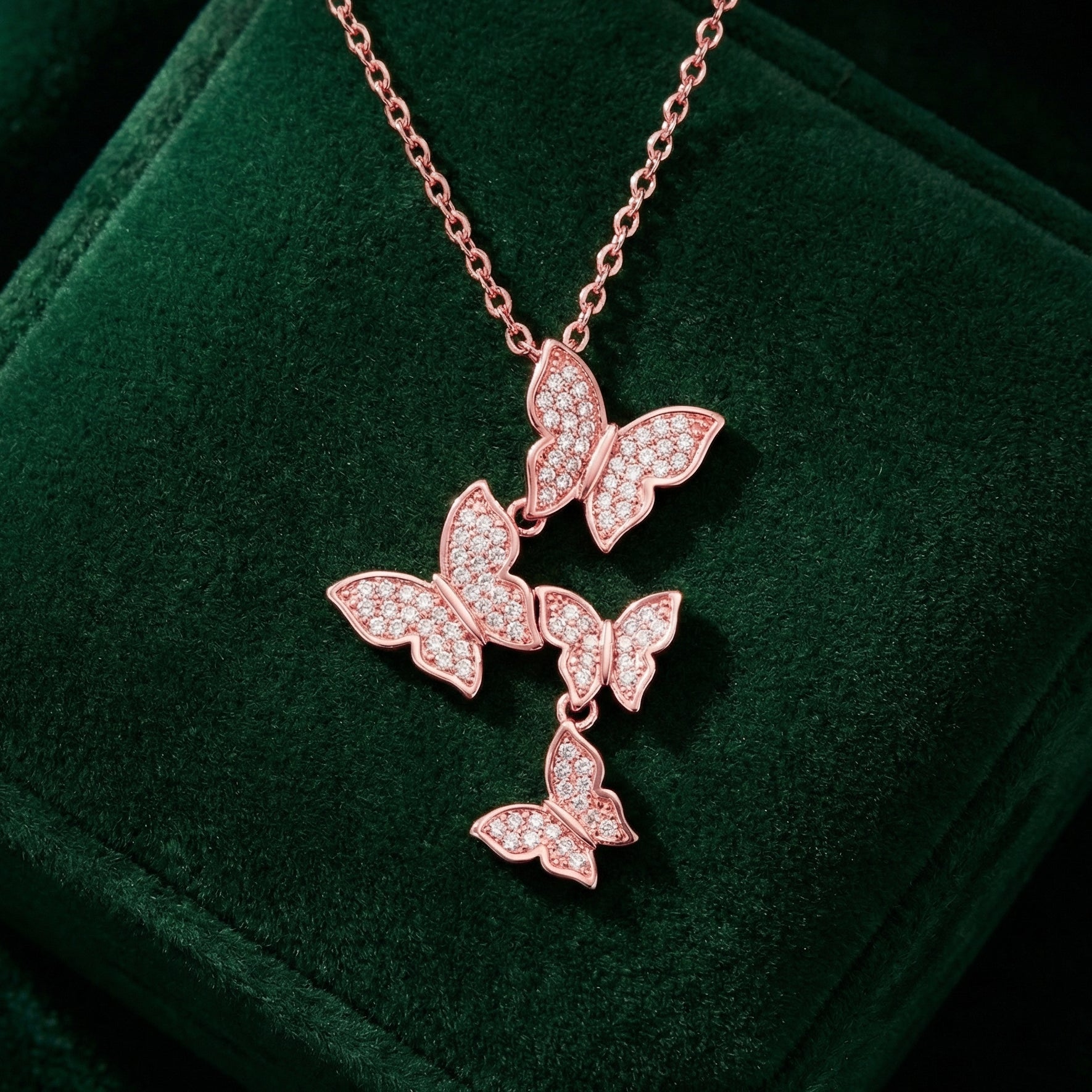 Rose gold butterfly necklace on a green velvet surface