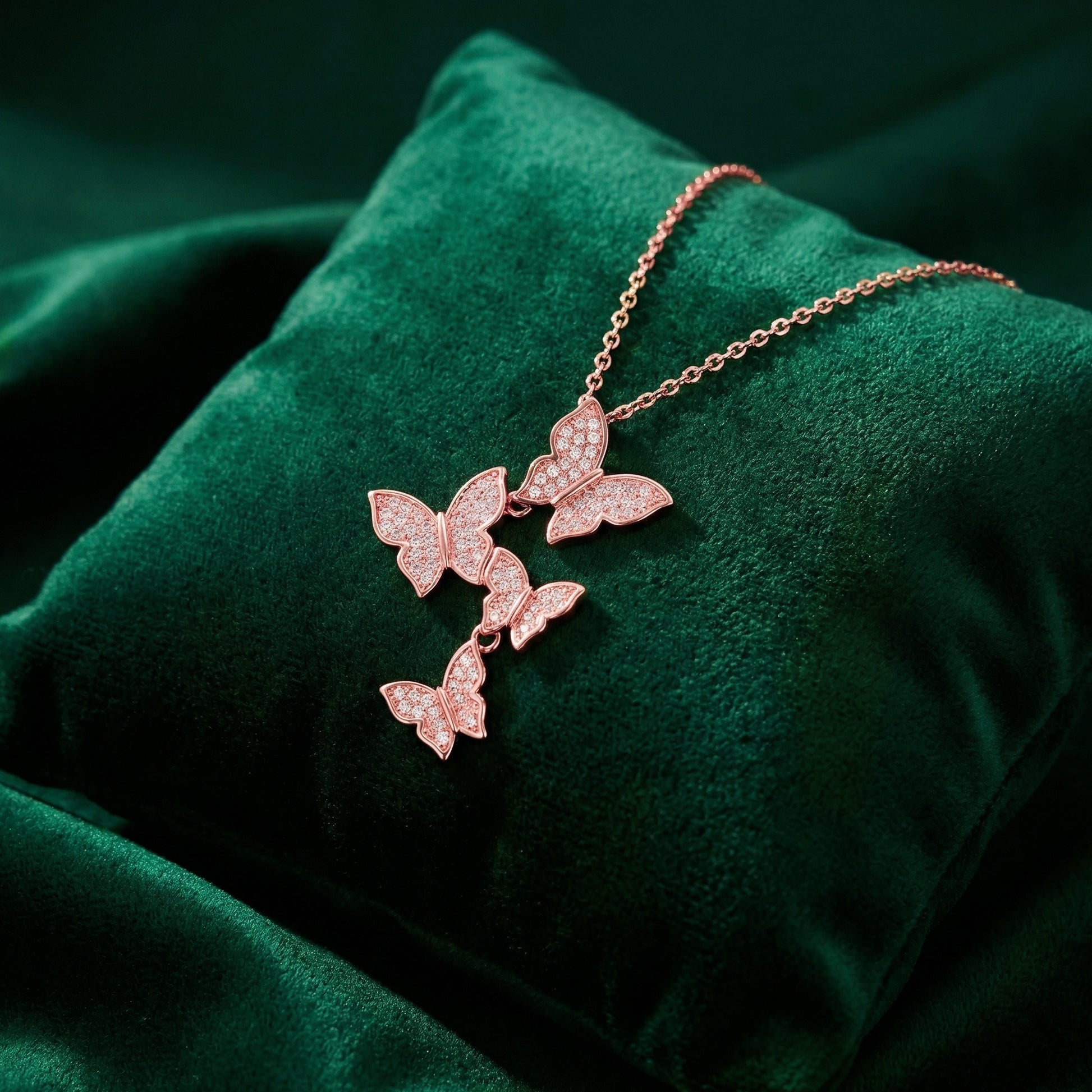 Rose gold butterfly necklace on a green velvet surface
