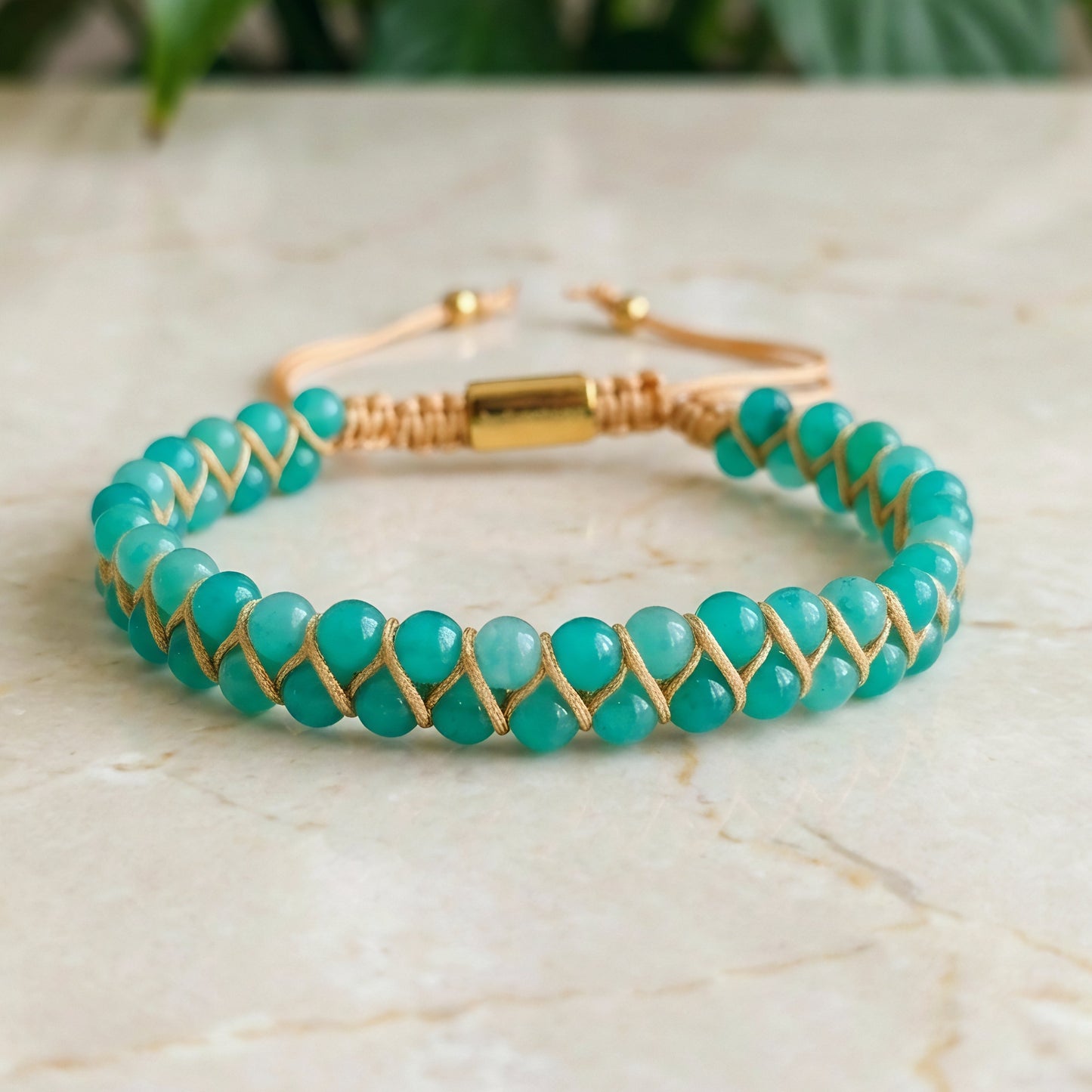 Turquoise beaded bracelet with Amazonite beads and gold accents on a marble surface