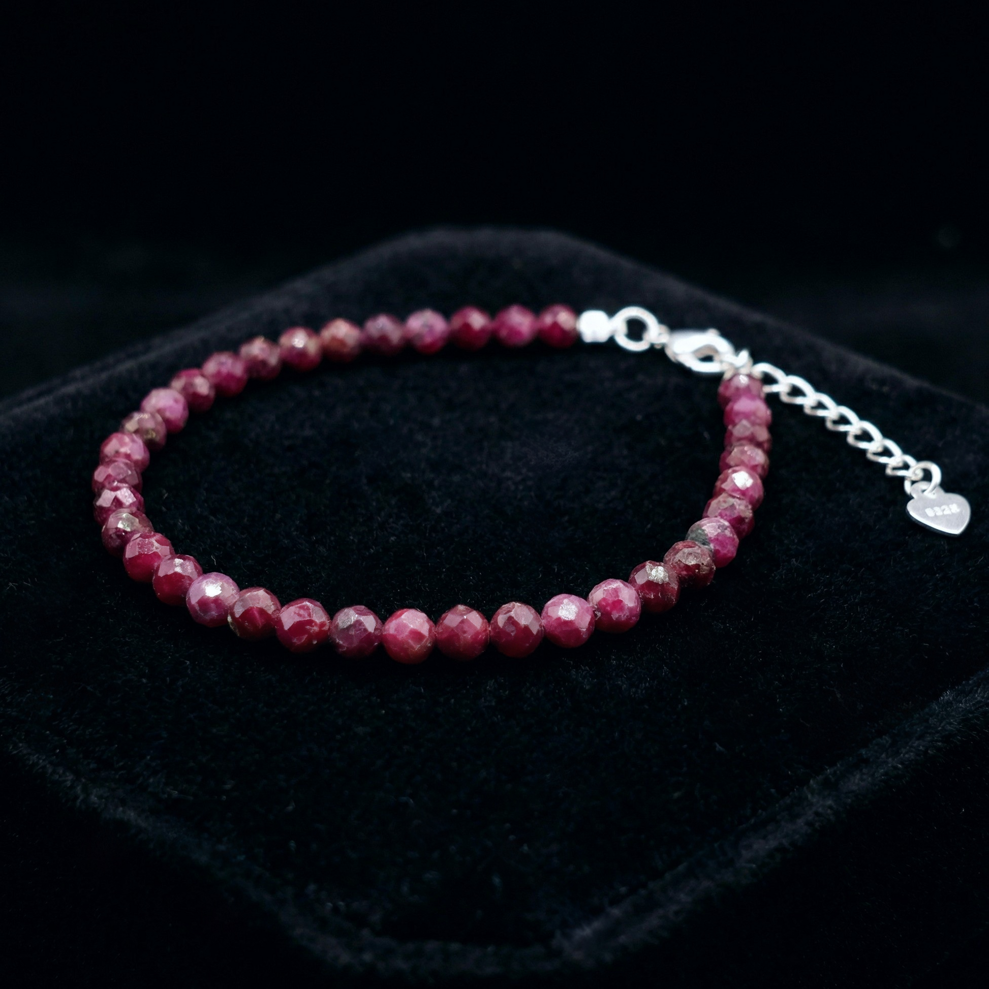 Beaded bracelet with 925 silver clasp with ruby beads on a black background