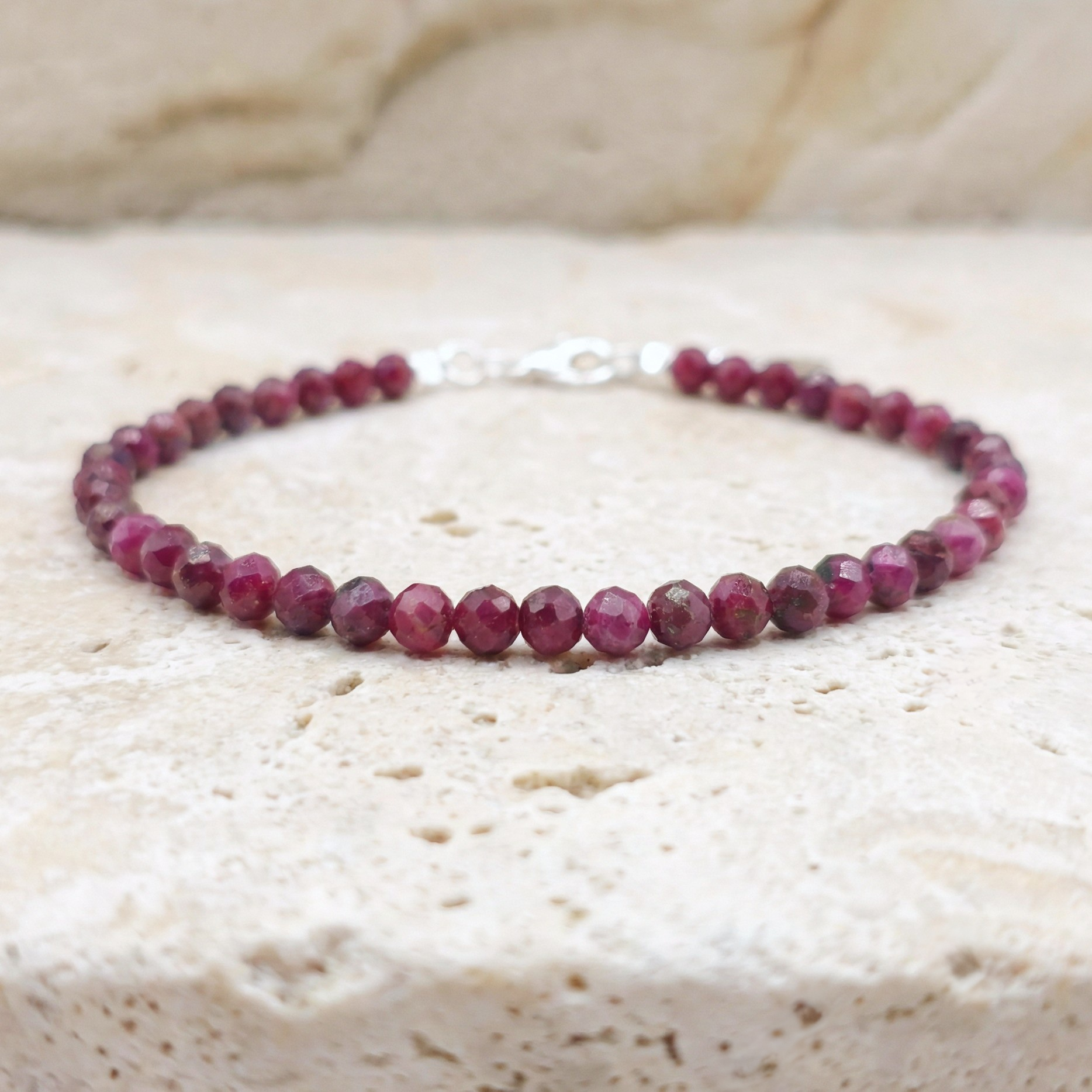 Ruby bracelet on a textured beige surface