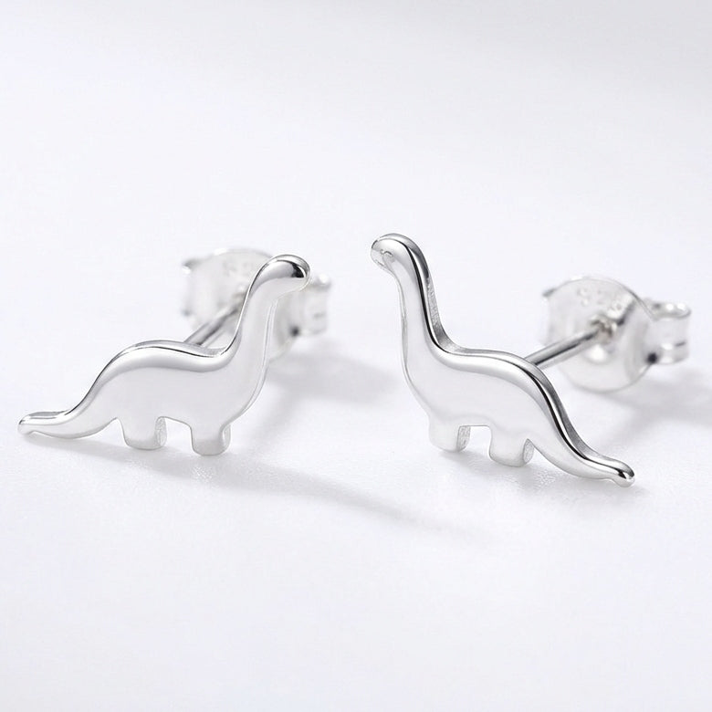 Silver dinosaur-shaped earrings on a white background