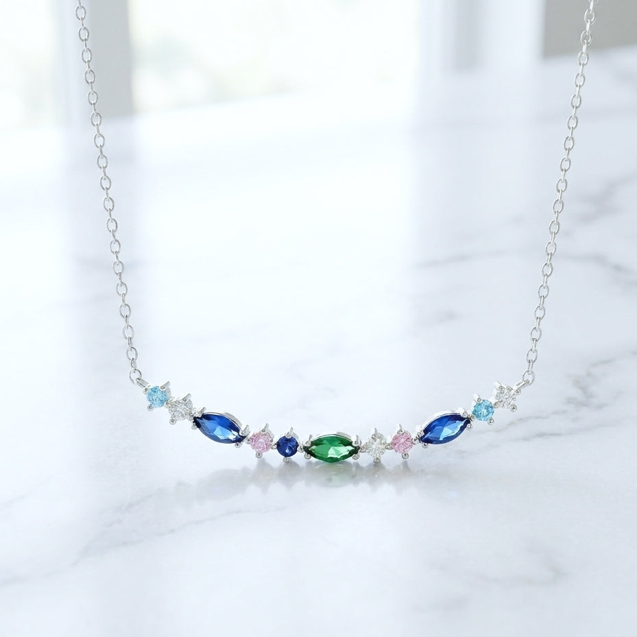 Fine silver necklace with colorful and sparkly gemstones on a light background
