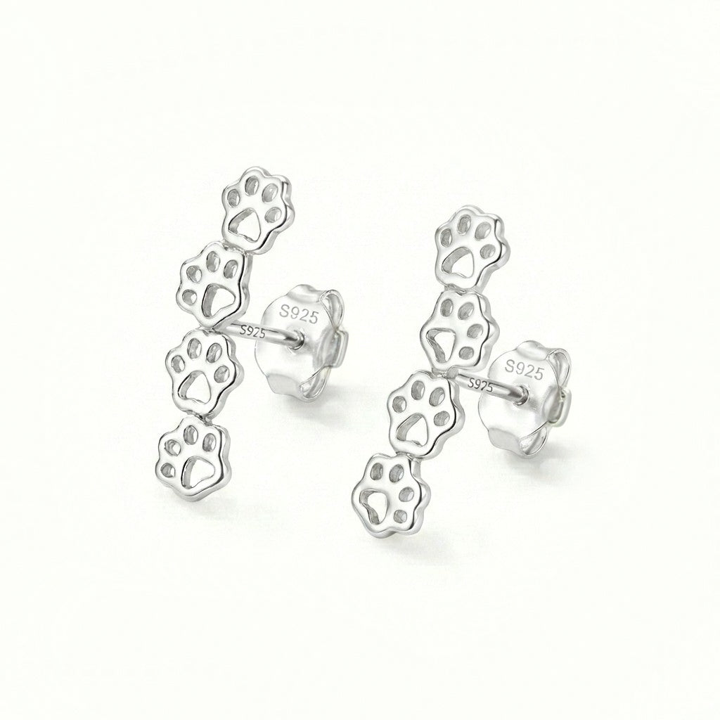 Silver paw print earrings on a white background