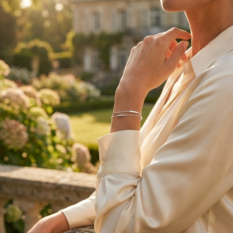 An elegant woman wearing a 925 Silver Bracelet featuring two Venetian box chains and long silver beads with fancy garden background