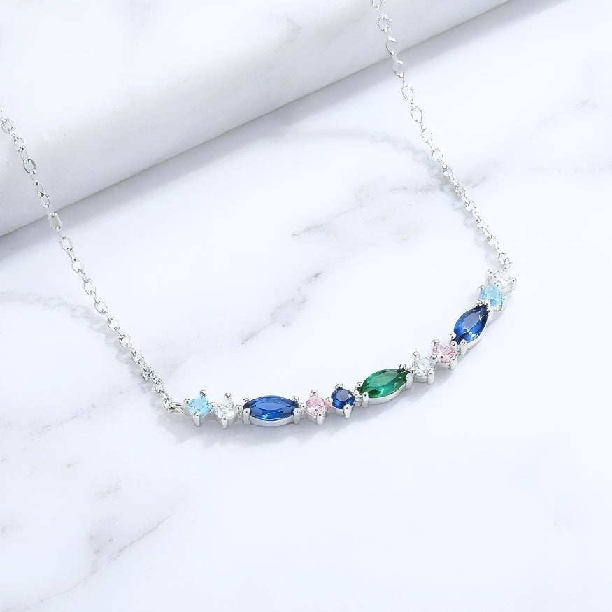 Bar shaped 925 silver pendant necklace with colorful blue and green gemstones on a white marble surface
