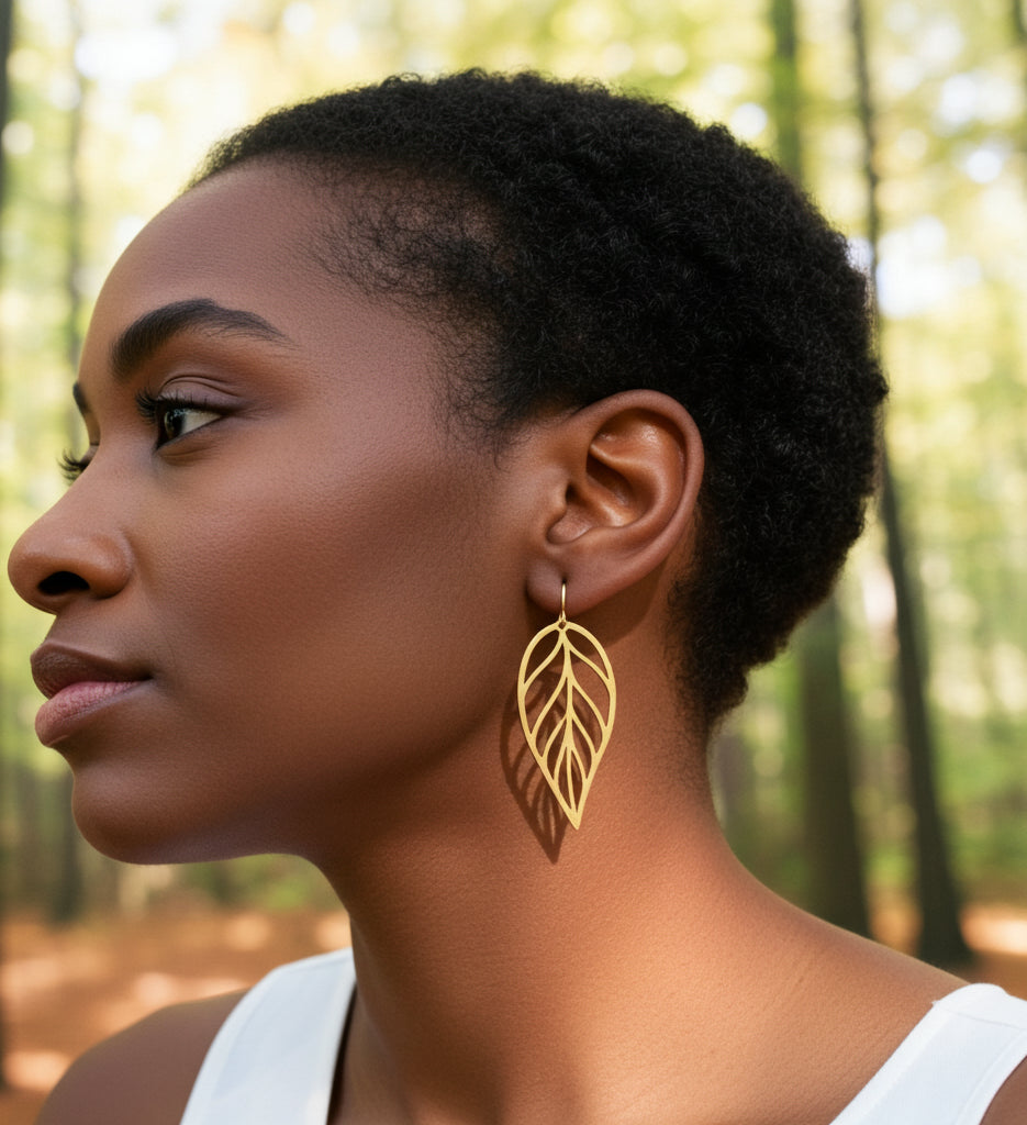 Woman wearing large gold stainless steel leaf earrings