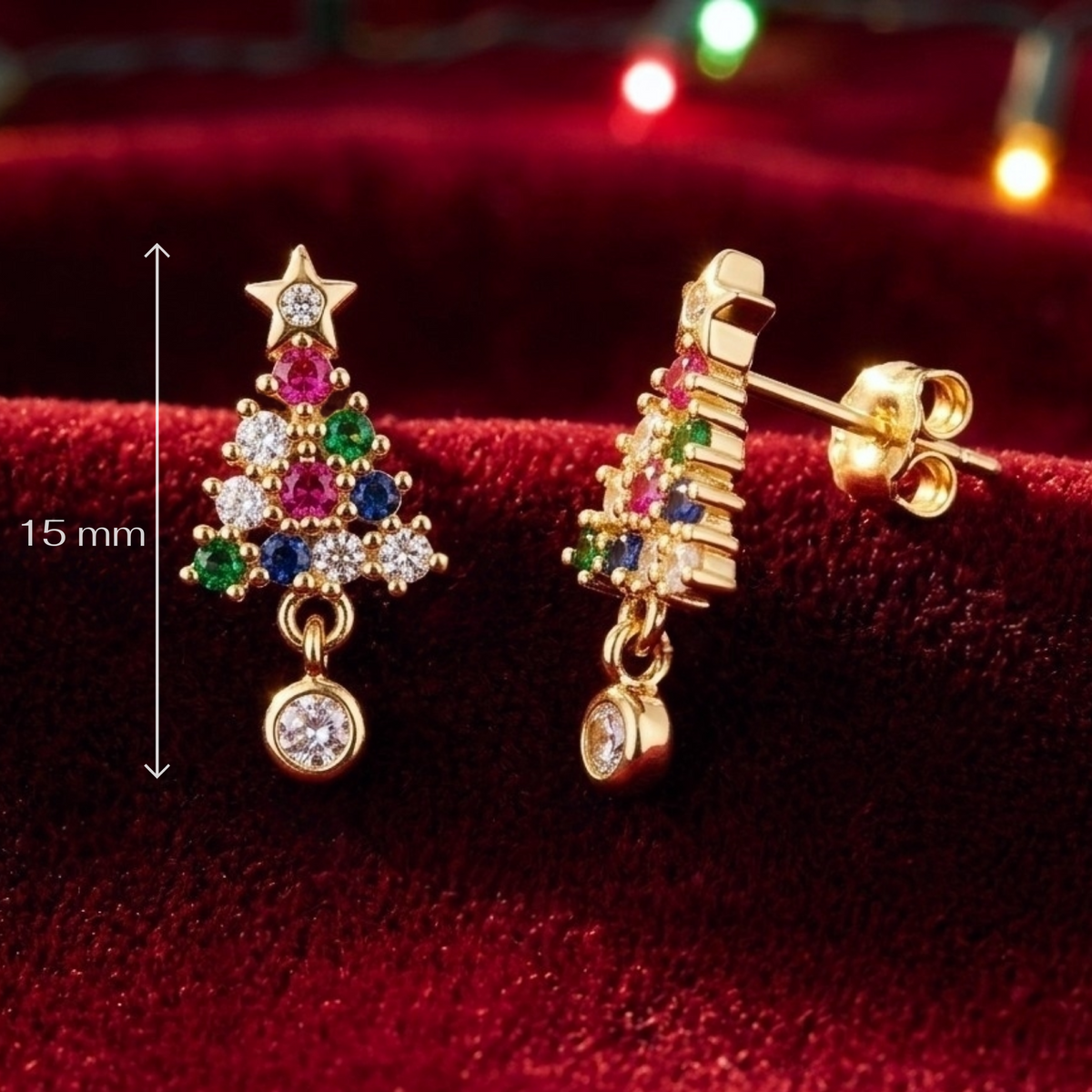 Gold-tone Christmas tree stud earrings with multicolored gemstones, shown on a dark red velvet background with a 15 mm height marker.