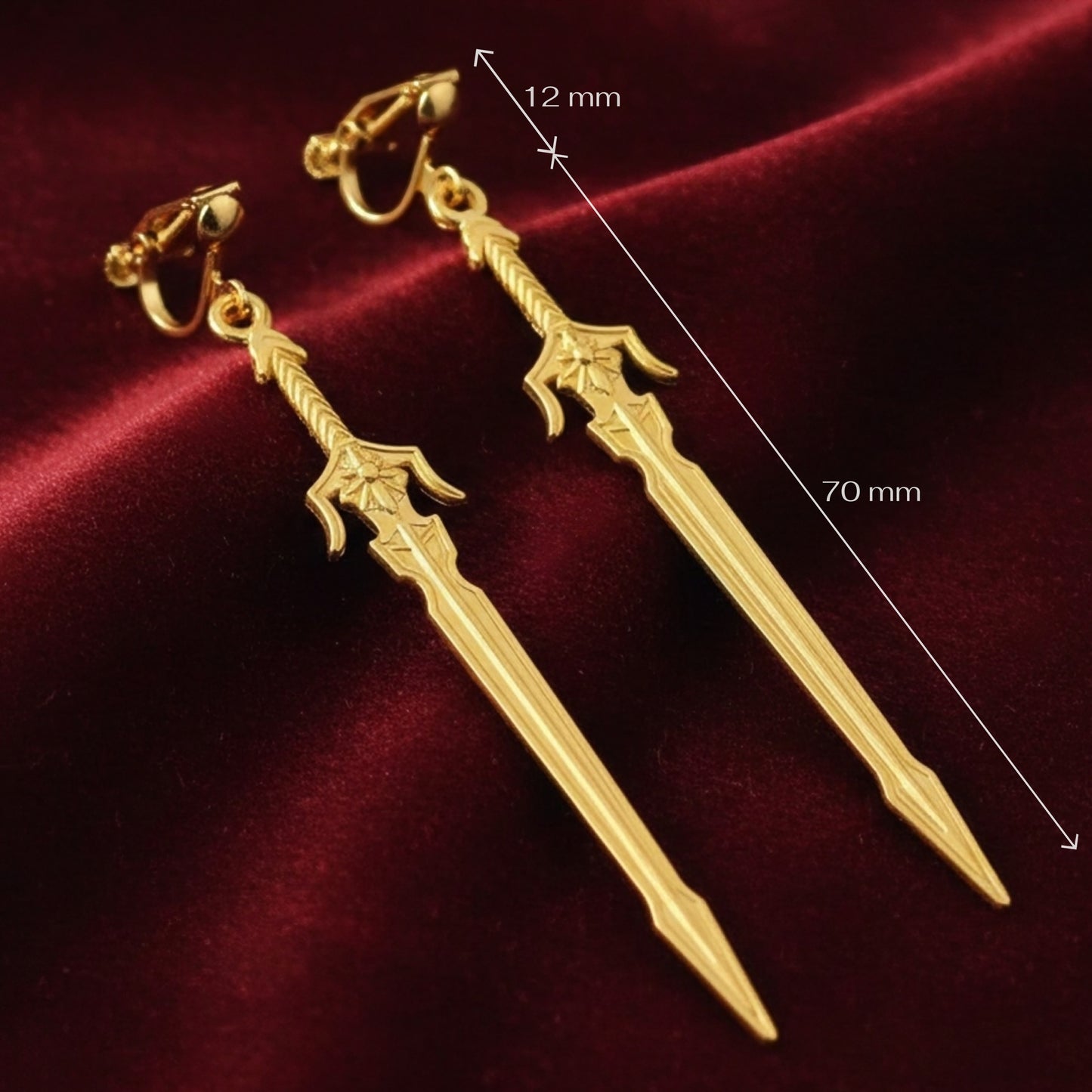 Medieval style fantasy long gold sword earrings with clip-on earrings on a red background with measurements