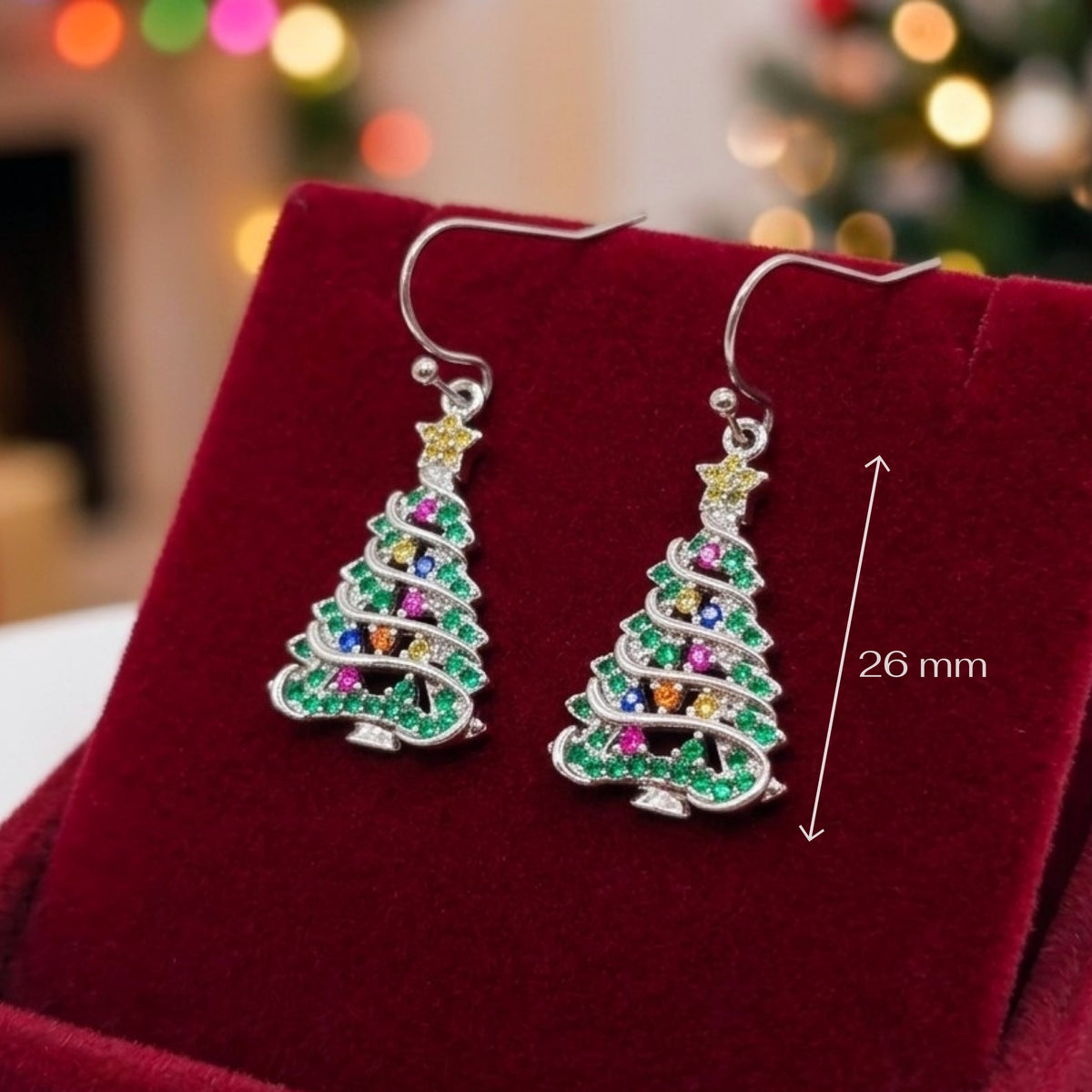 A pair of silver tree-shaped drop earrings decorated with green, pink, orange, and yellow cubic zirconia crystals, displayed on a red velvet jewelry box with a 26 mm size indicator.