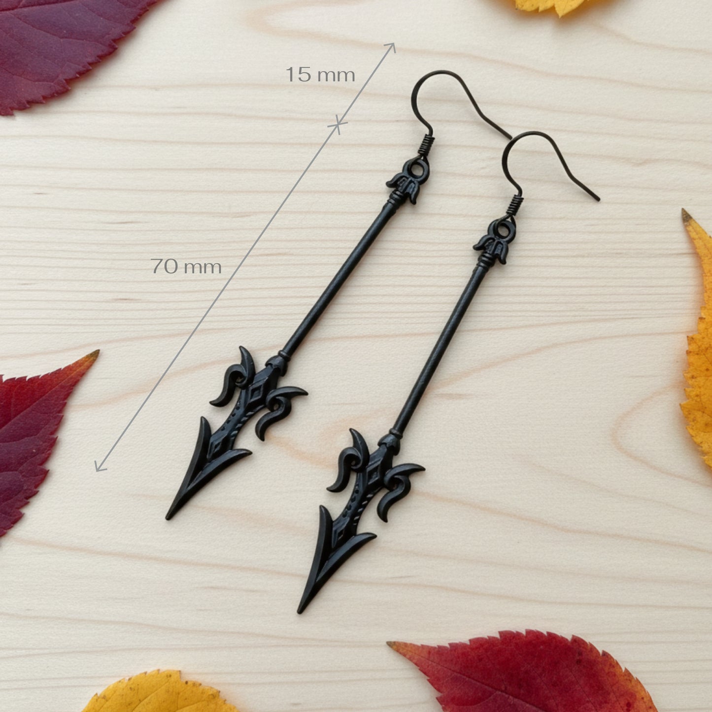 long black mace or axe earrings on a wood background with measurements