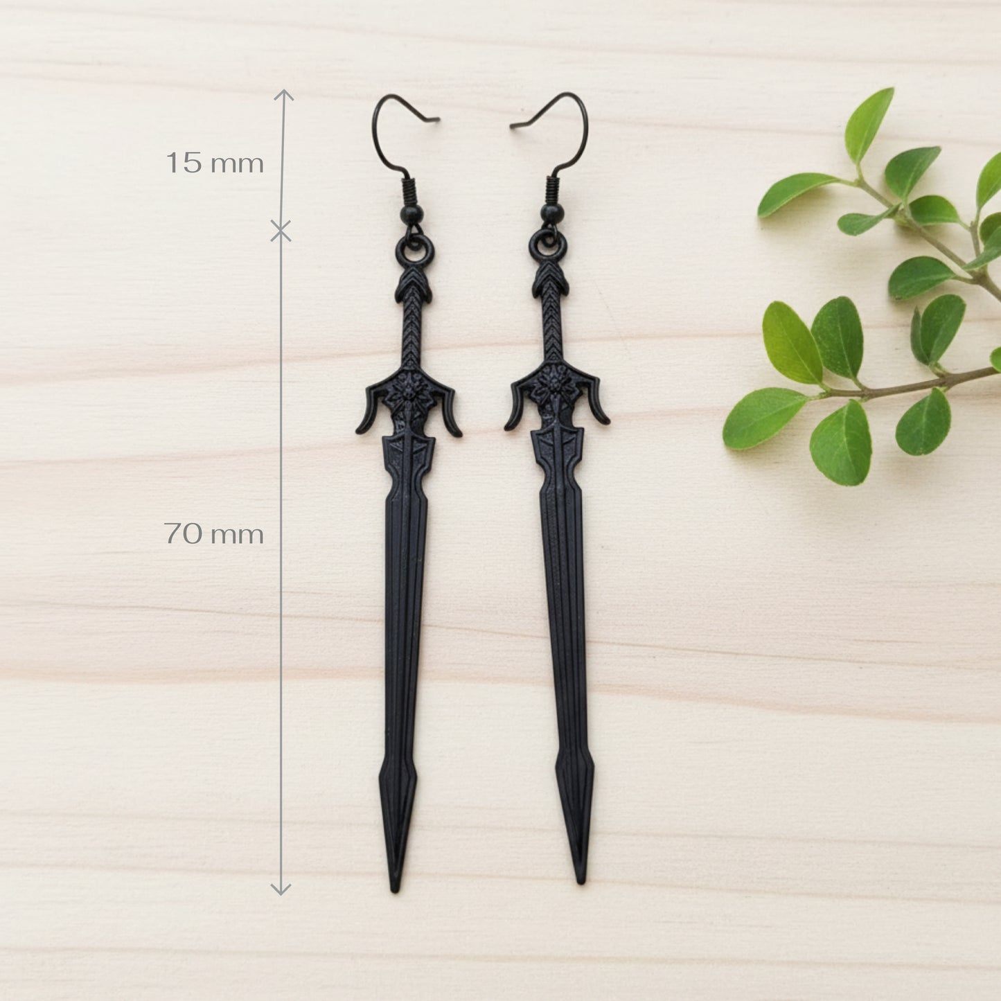 long black sword earrings on a wood background with measurements