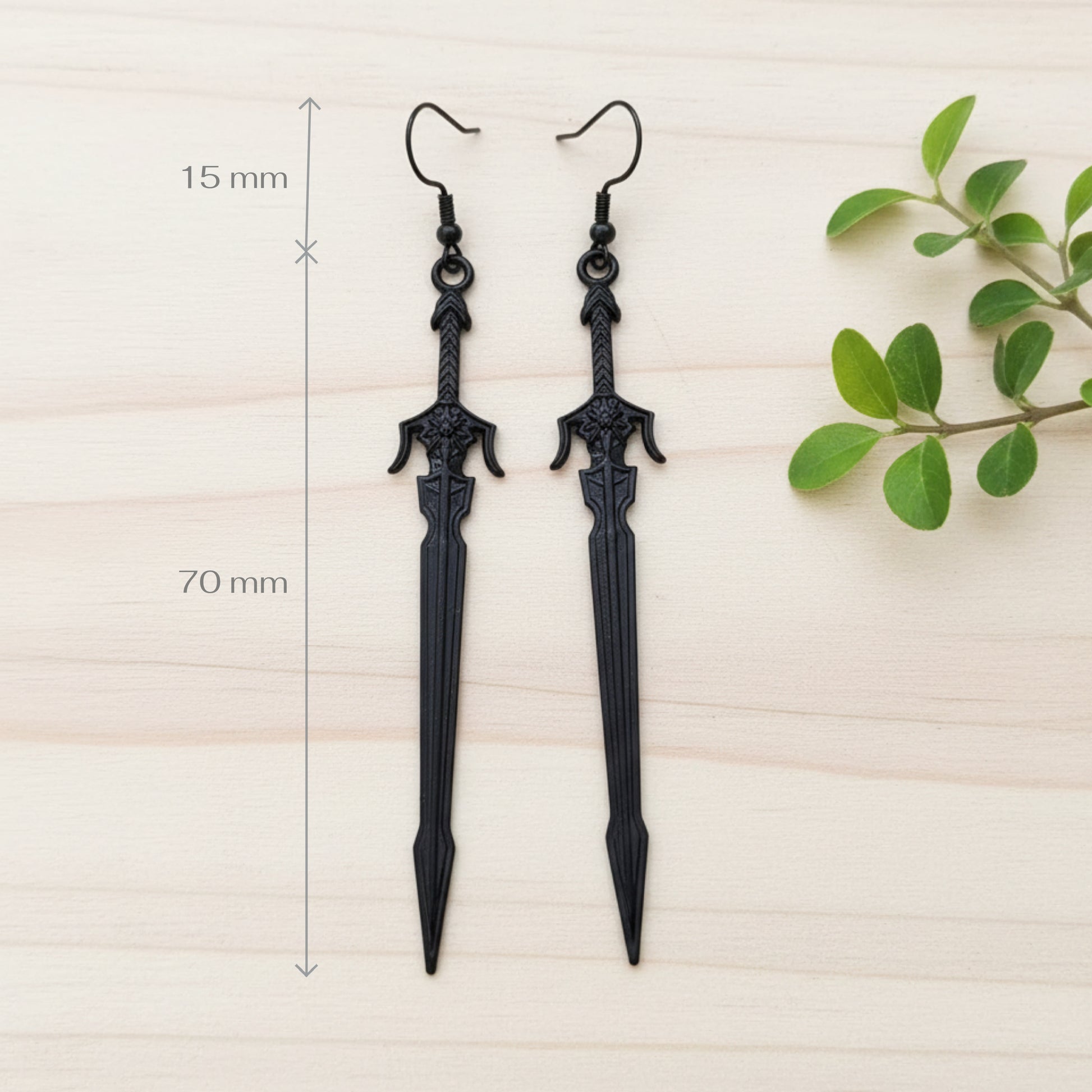 long black sword earrings on a wood background with measurements