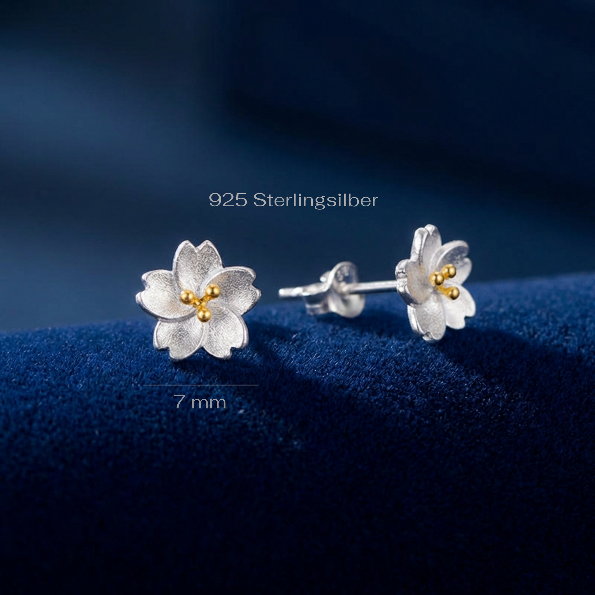 Dainty flower stud earrings with measurements on a blue background