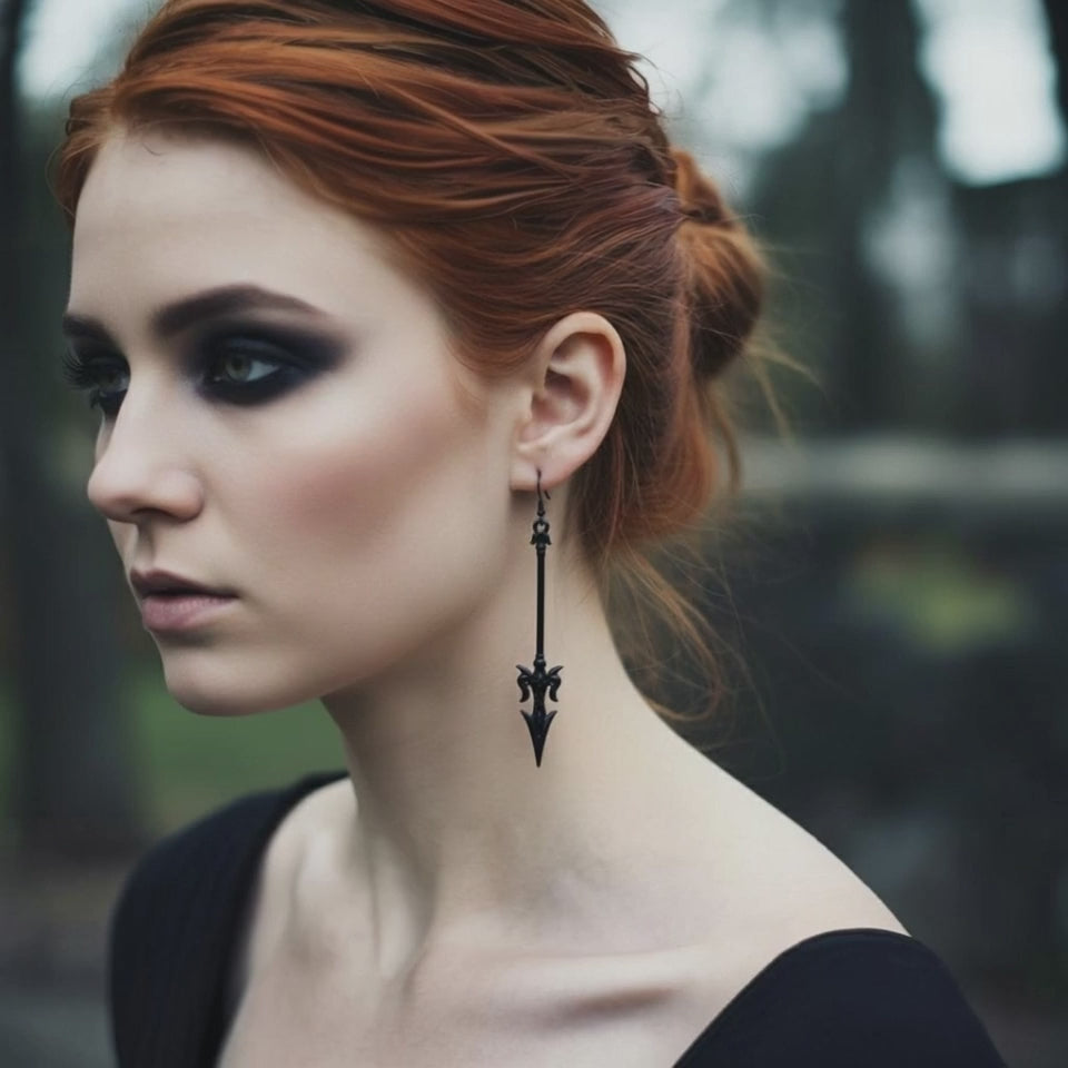 A gothic woman with red hair wearings long black mace or axe earrings