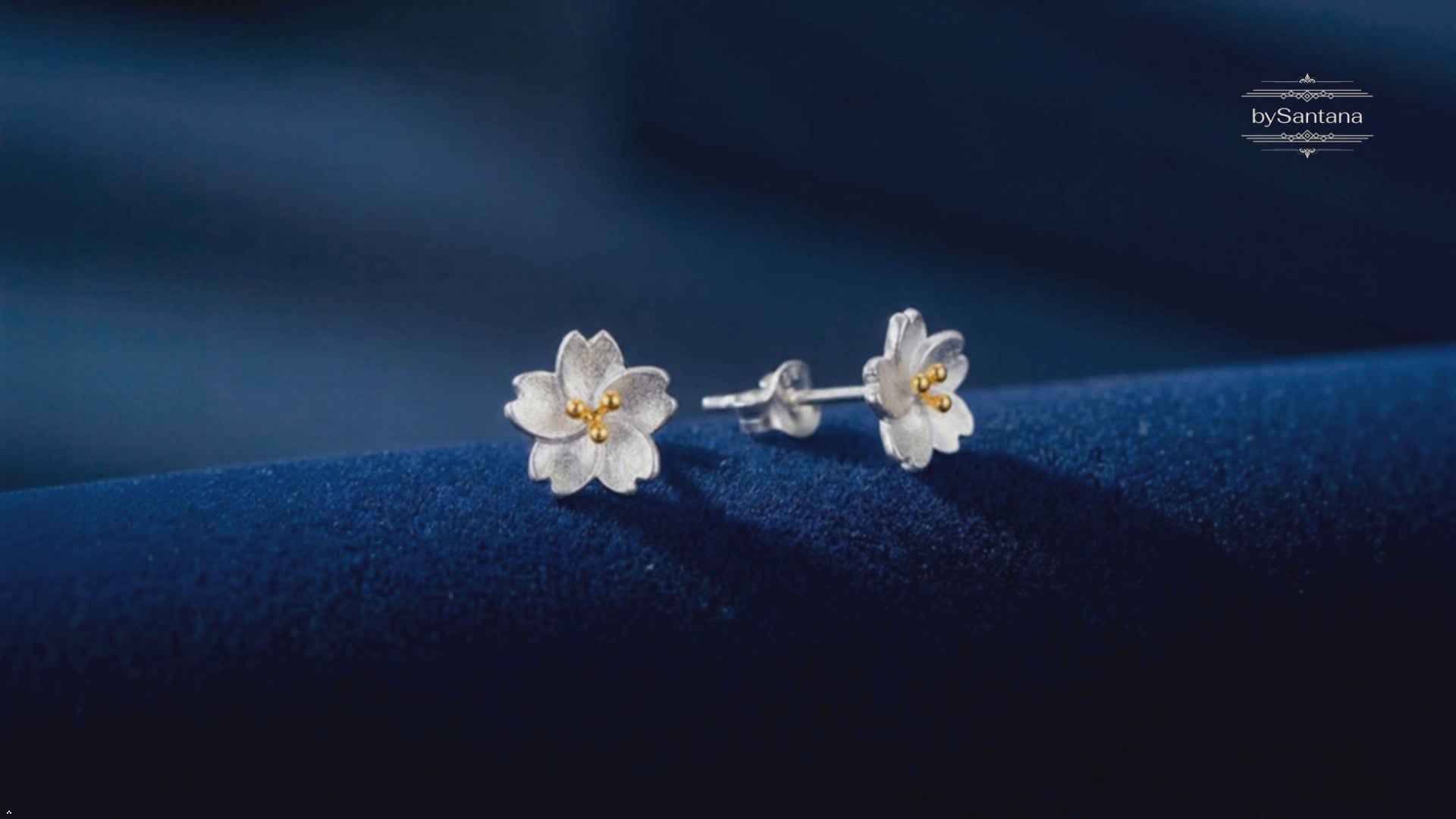 Video showing the silver flower stud earrings turning on a green background