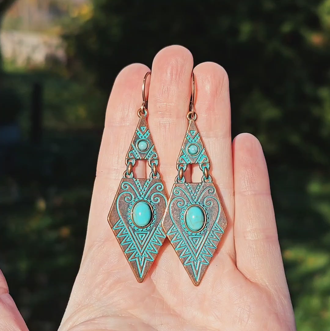 Copper and turquoise boho dangle earrings shining in sunlight outside