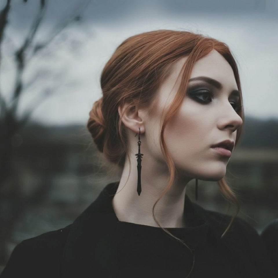 A gothic woman wearing long black sword earrings